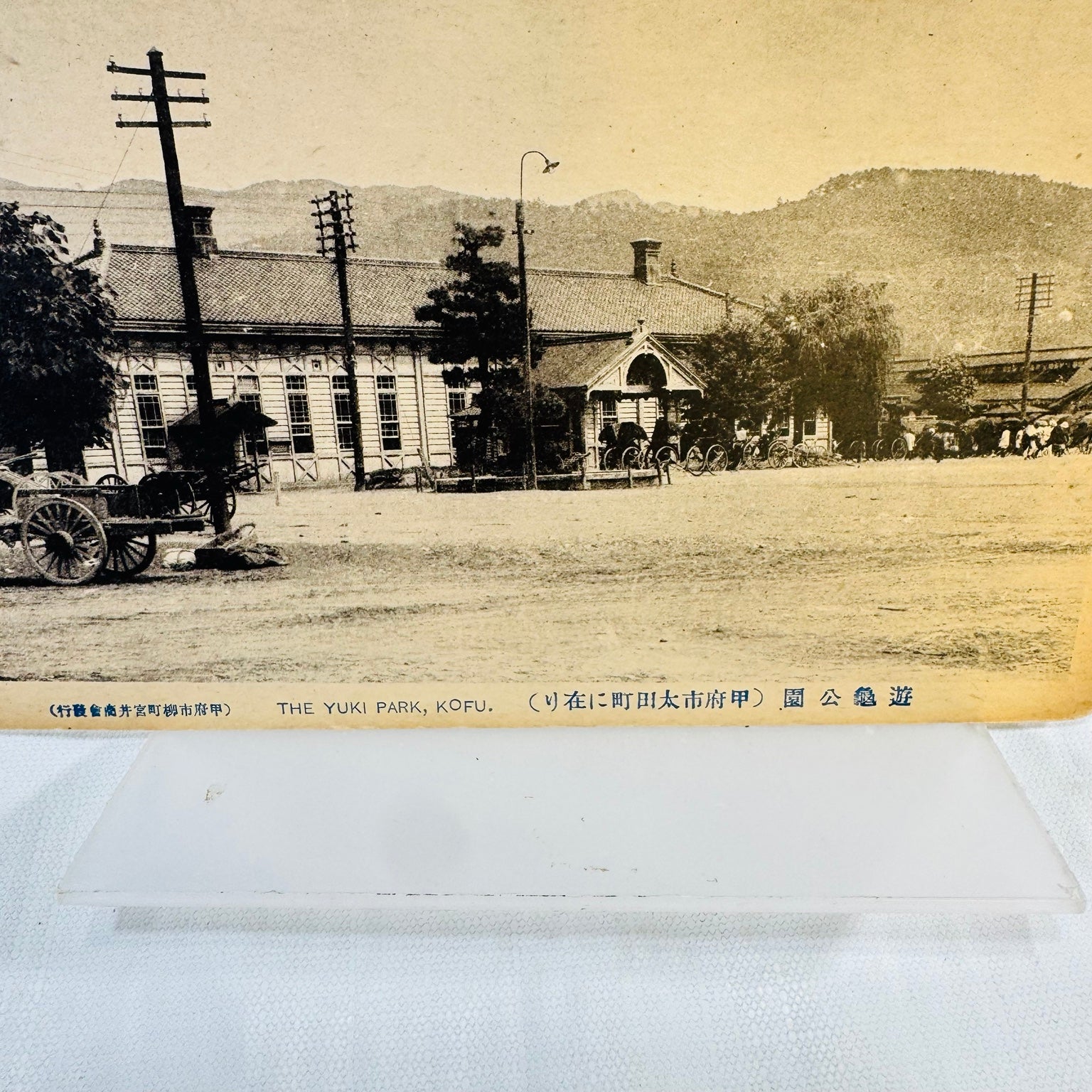 Sepia Yuki Park Kofu Japan postcard showing a building, wooden cart and mountain backdrop