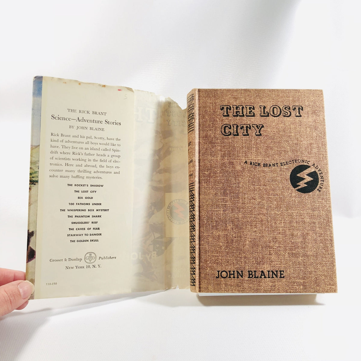 Tan cloth cover with lightning bolt logo, The Lost City by John Blaine