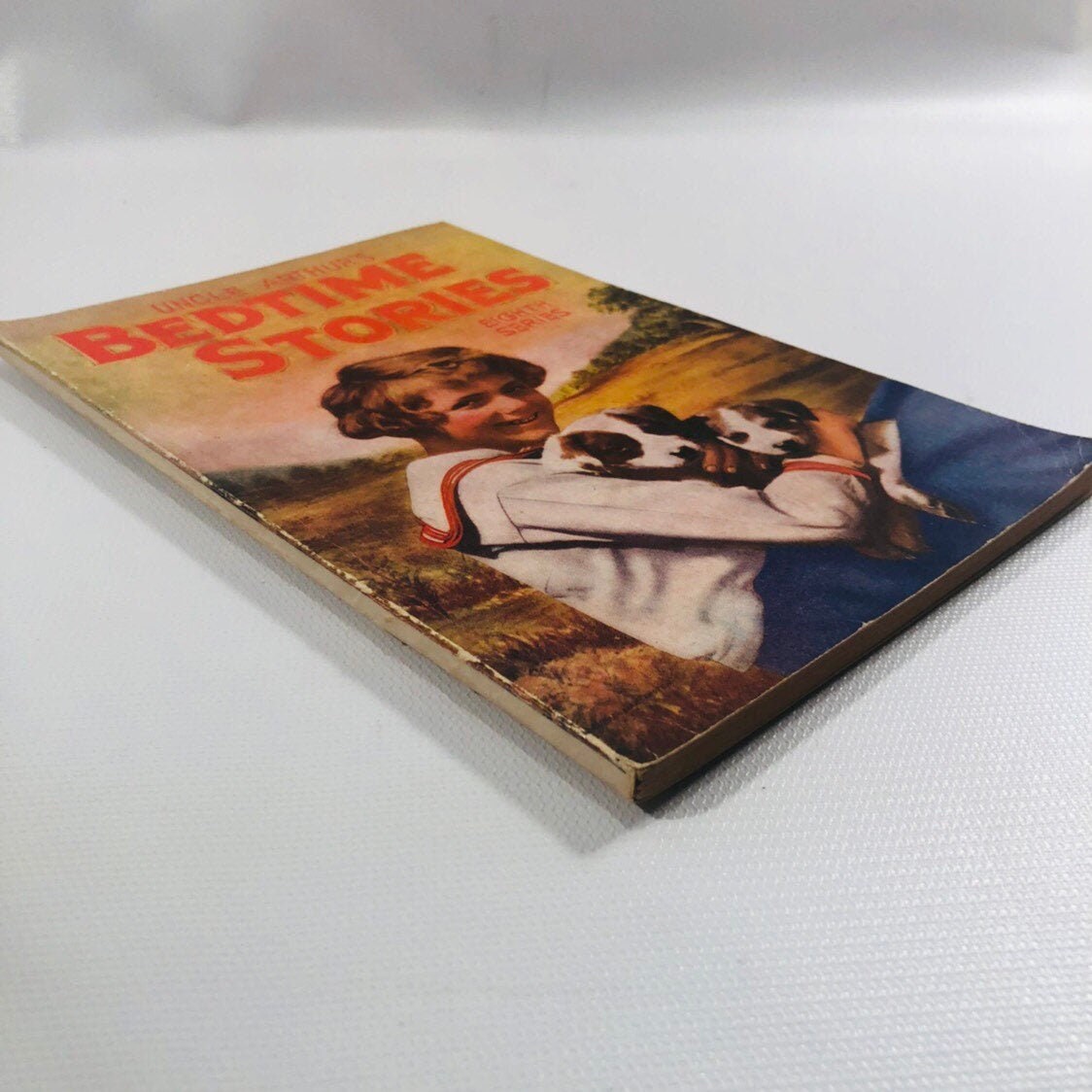 Uncle Arthur's Bedtime Stories 1931 lying at an angle, showing spine edge wear