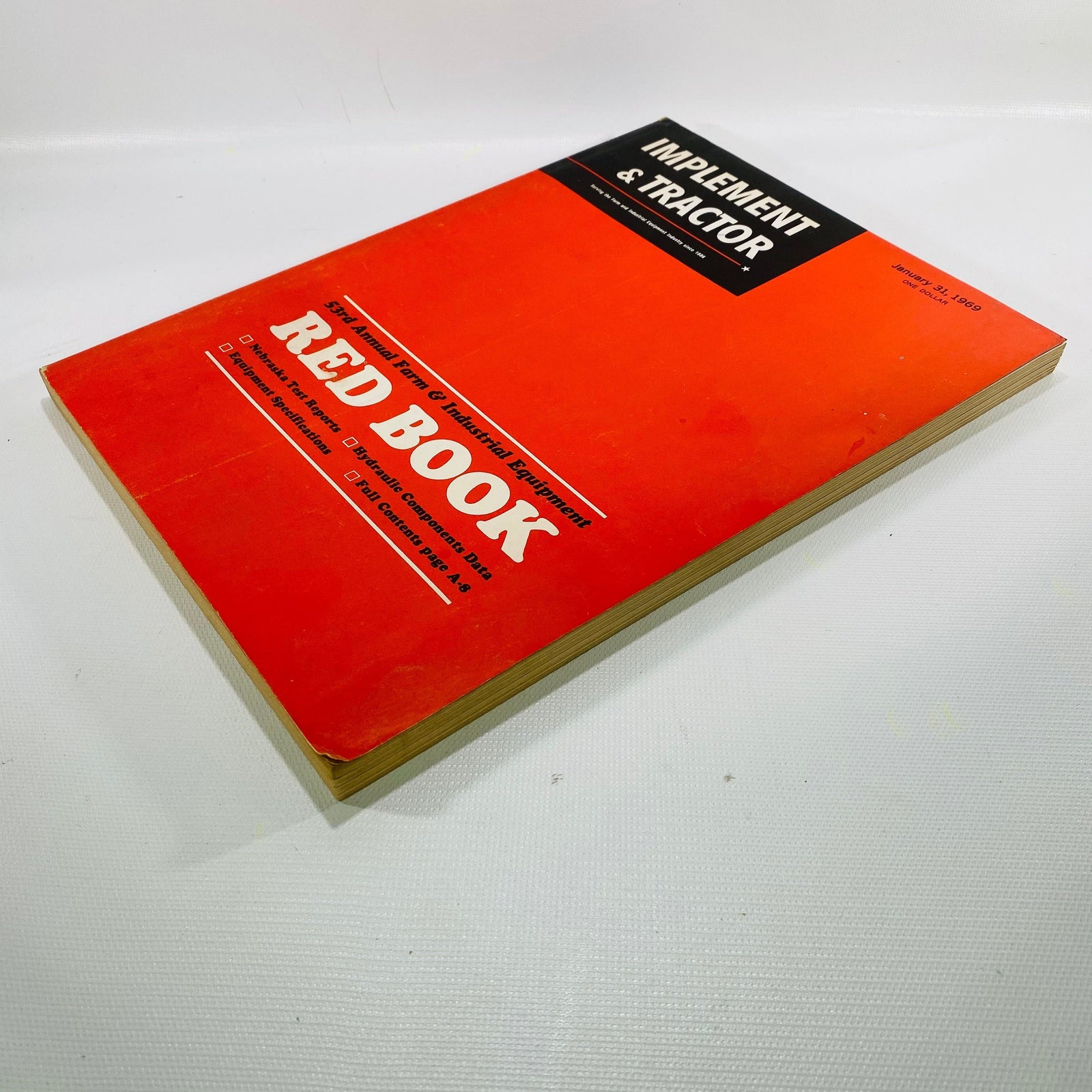 Implement & Tractor Red Book 1969 lying at an angle, showing cover wear