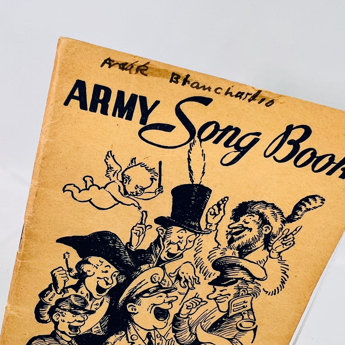 Close view of the Army Song Book 1941 cover art and handwritten name
